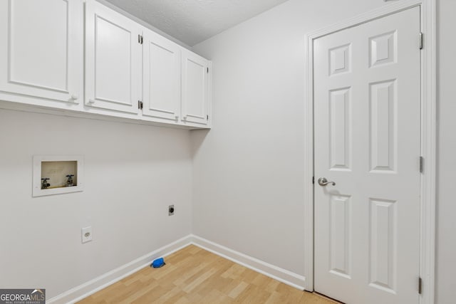 clothes washing area with hookup for a washing machine, baseboards, cabinet space, light wood finished floors, and electric dryer hookup