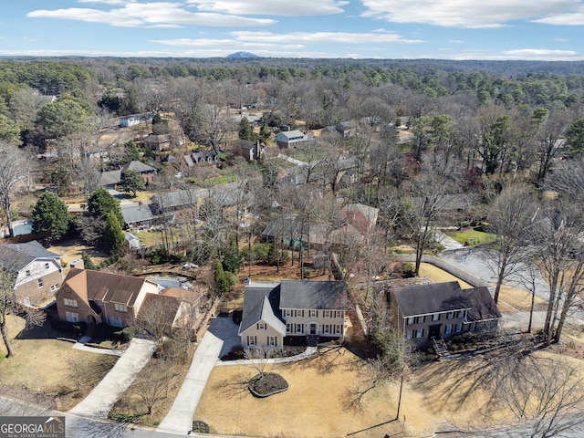 bird's eye view with a wooded view