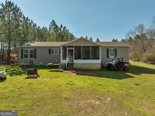 rear view of property with a yard, crawl space, and a sunroom