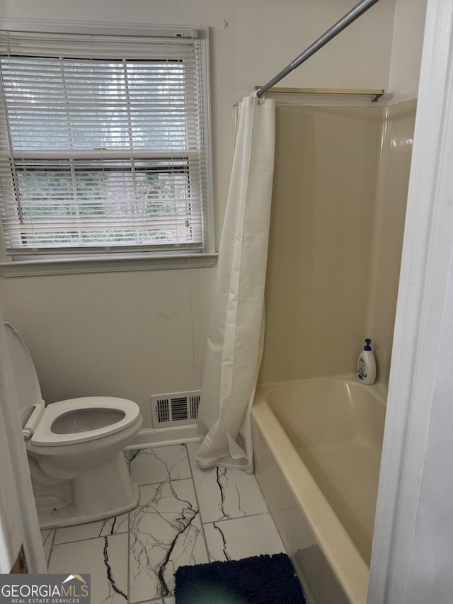 bathroom with toilet, marble finish floor, visible vents, and shower / tub combo with curtain