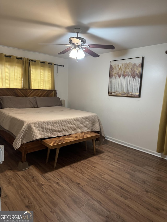 bedroom with a ceiling fan, baseboards, and wood finished floors