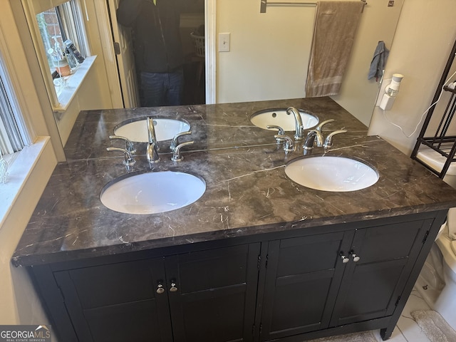 bathroom with a sink and double vanity