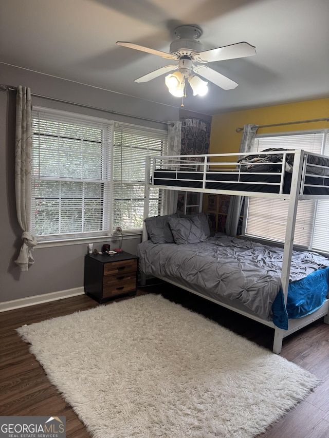 bedroom featuring a ceiling fan, baseboards, and wood finished floors