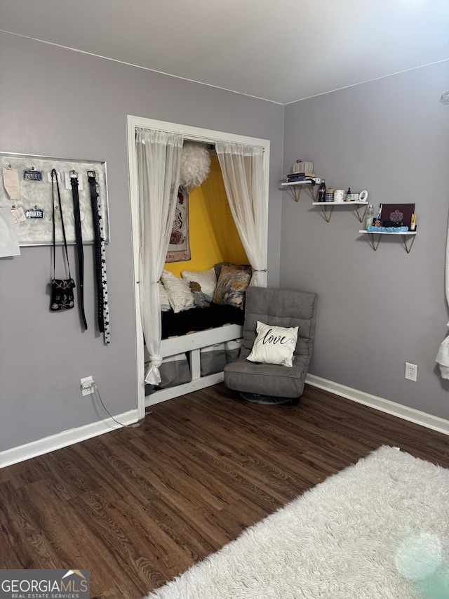 living area featuring baseboards and wood finished floors