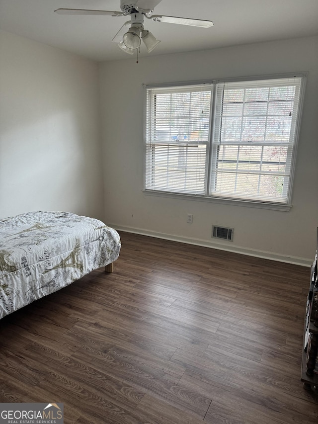 bedroom featuring dark wood-style flooring, visible vents, and baseboards