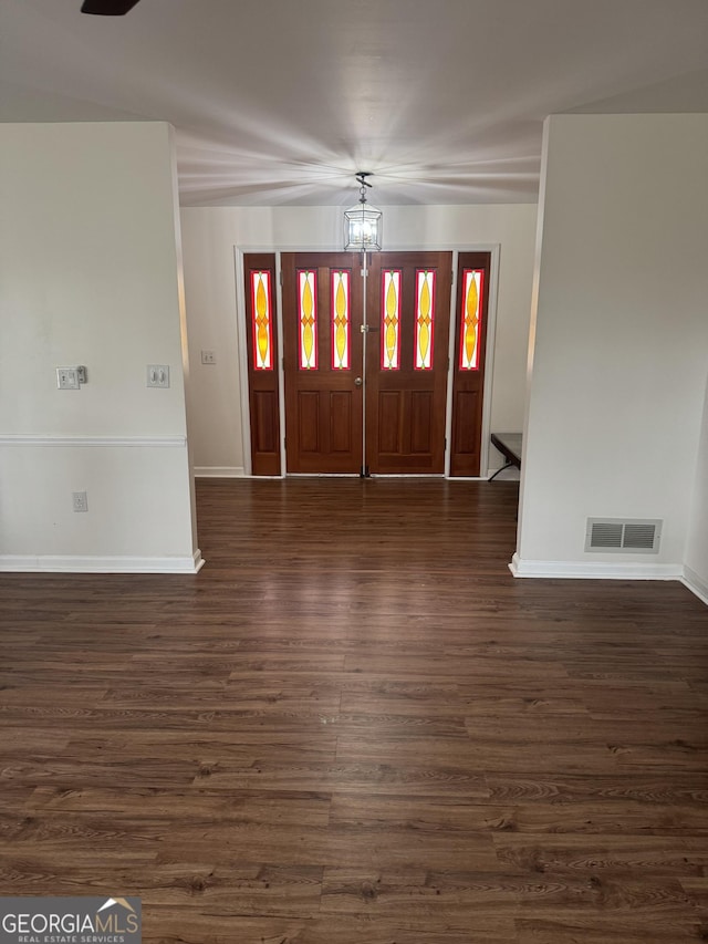 entryway featuring dark wood-style floors, baseboards, visible vents, and an inviting chandelier