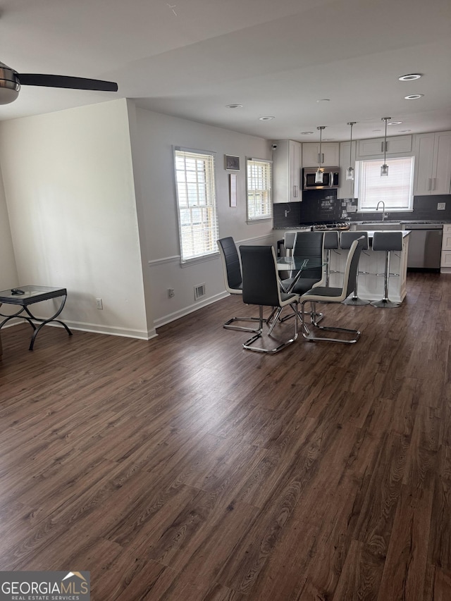 interior space featuring baseboards, visible vents, dark wood finished floors, and recessed lighting