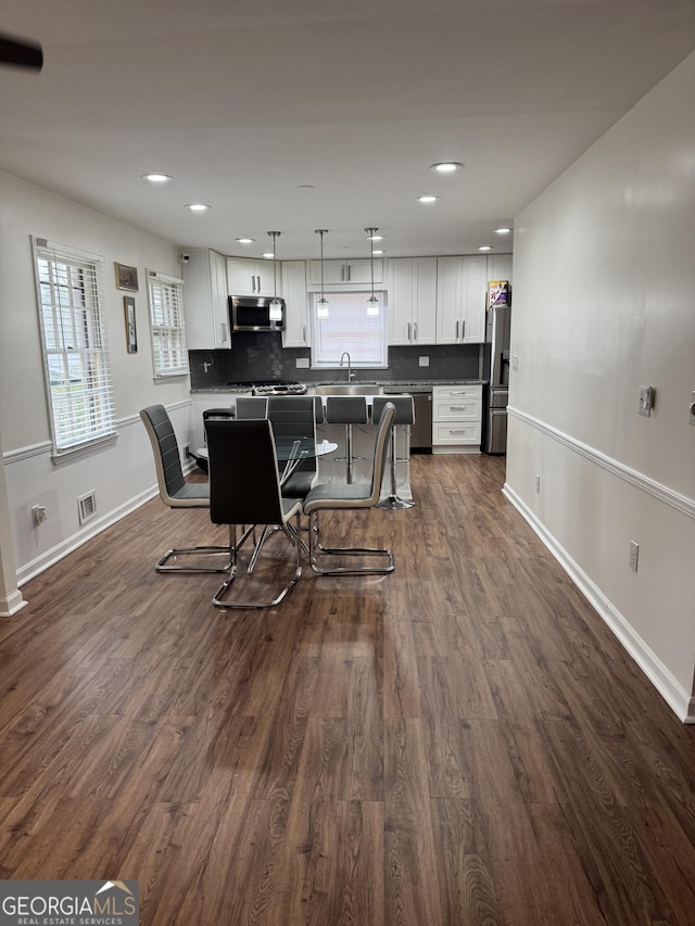 kitchen with stainless steel appliances, visible vents, white cabinets, tasteful backsplash, and dark wood finished floors