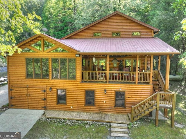 rear view of property with metal roof, stairway, and log veneer siding