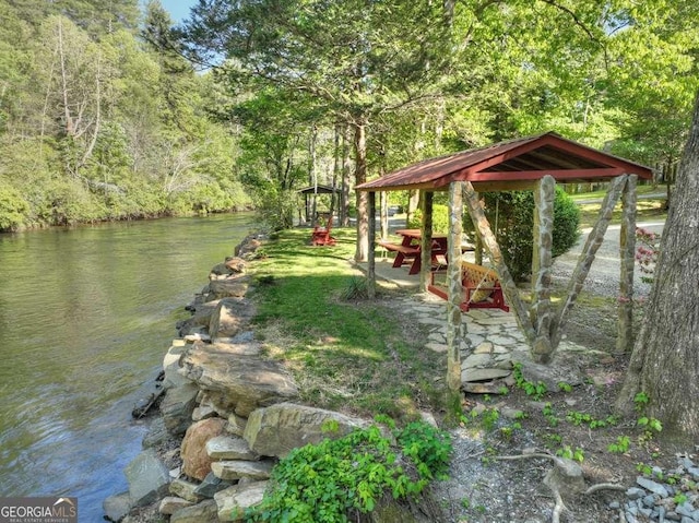 view of yard with a water view and a wooded view