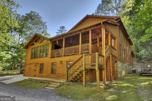 rear view of property featuring central air condition unit, ceiling fan, stairway, and log veneer siding