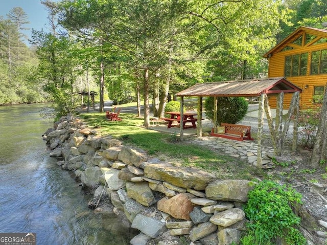 view of yard featuring a water view and a view of trees