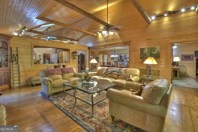 living area with wooden walls, a ceiling fan, wooden ceiling, hardwood / wood-style flooring, and beamed ceiling