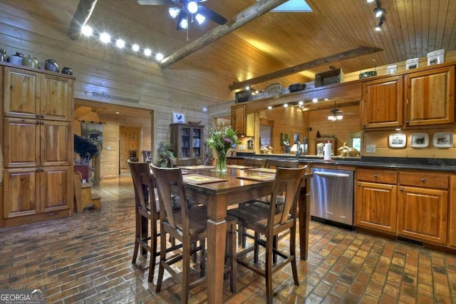 dining space with wood ceiling, wood walls, and ceiling fan