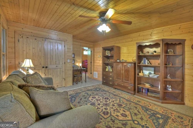 living area featuring carpet floors, wood ceiling, wooden walls, and visible vents