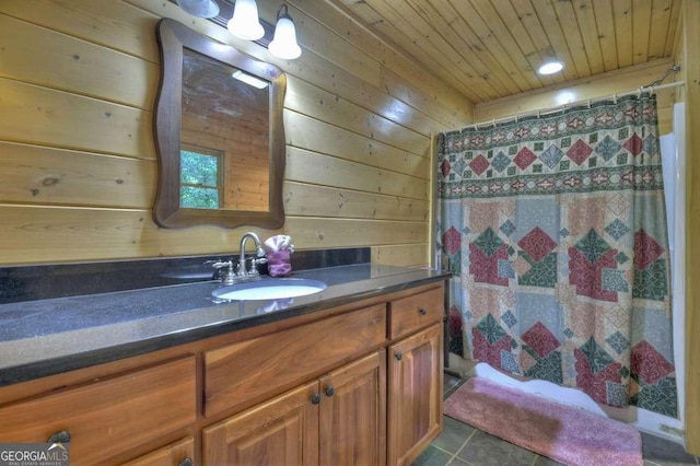 bathroom featuring curtained shower, wood walls, vanity, wooden ceiling, and tile patterned floors