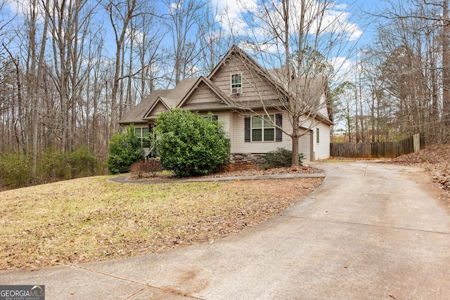 view of front of property with a garage, fence, a front lawn, and concrete driveway