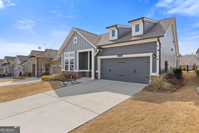 6968 River Rock Dr, Flowery Branch, GA 30542 - view of front of house with board and batten siding, concrete driveway, stone siding, an attached garage, and a shingled roof
