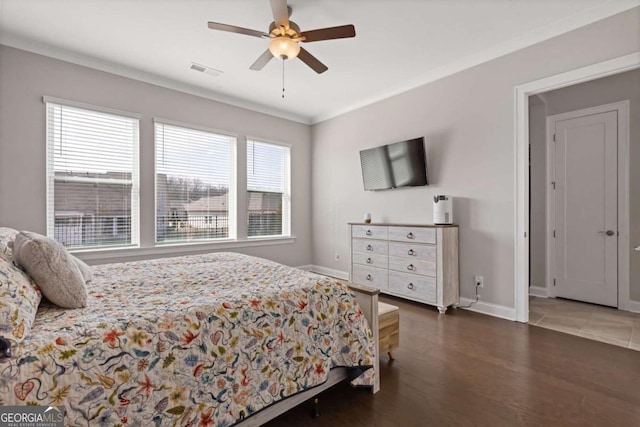 bedroom with baseboards, visible vents, wood finished floors, and ornamental molding