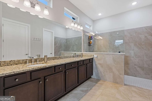 full bath with double vanity, walk in shower, a sink, and recessed lighting