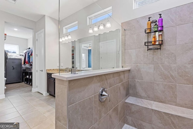 full bath with a walk in closet, tile patterned flooring, walk in shower, and vanity