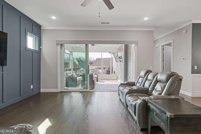 living room with baseboards, visible vents, ceiling fan, ornamental molding, and dark wood-type flooring