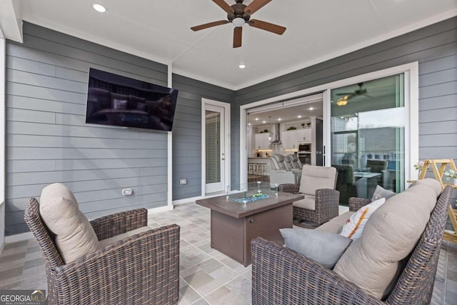 view of patio / terrace featuring a ceiling fan and an outdoor living space with a fire pit