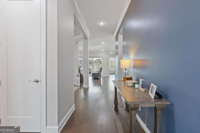 corridor featuring ornamental molding, recessed lighting, wood finished floors, and baseboards