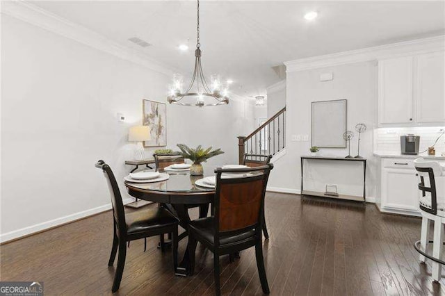 dining space featuring ornamental molding, dark wood-style flooring, baseboards, and an inviting chandelier