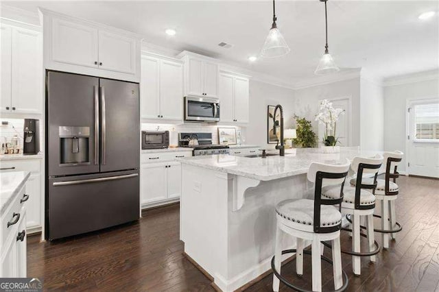 kitchen featuring a sink, white cabinets, appliances with stainless steel finishes, tasteful backsplash, and crown molding