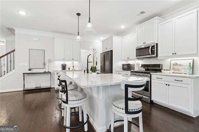 kitchen featuring dark wood-style floors, stainless steel appliances, decorative backsplash, ornamental molding, and white cabinetry