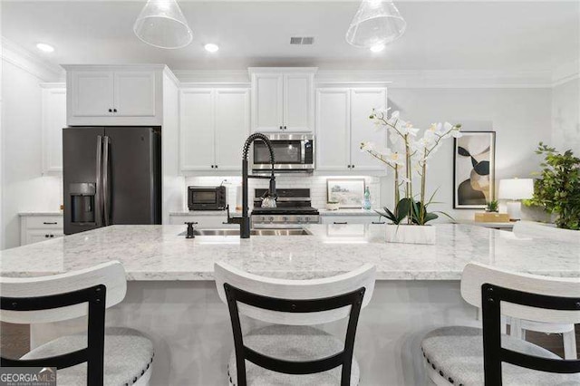 kitchen featuring black refrigerator with ice dispenser, stainless steel microwave, white cabinetry, and tasteful backsplash