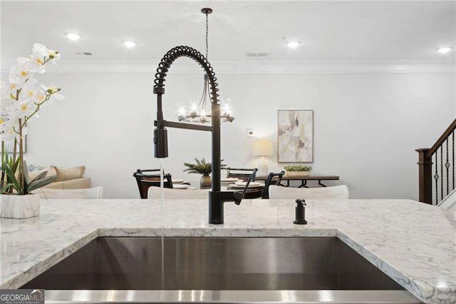 details featuring light stone countertops, ornamental molding, a sink, and recessed lighting