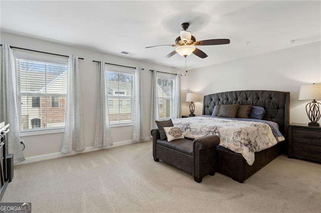 bedroom featuring light carpet, baseboards, visible vents, and a ceiling fan