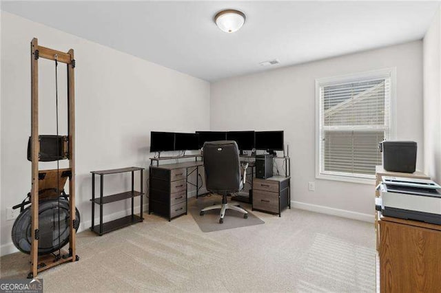 office area featuring light carpet, visible vents, and baseboards