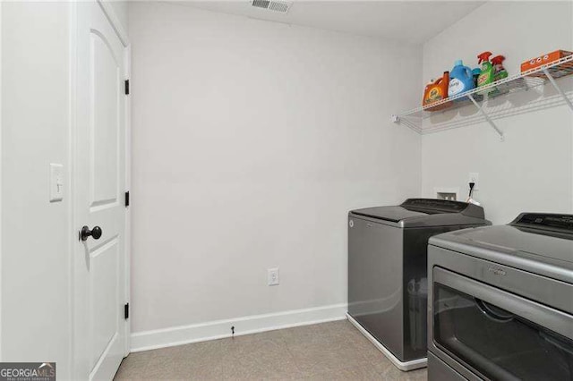 clothes washing area featuring laundry area, visible vents, baseboards, light floors, and washing machine and clothes dryer