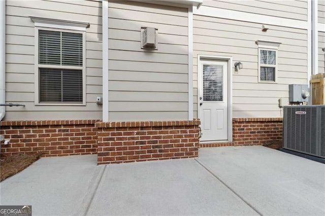 entrance to property with central AC and brick siding