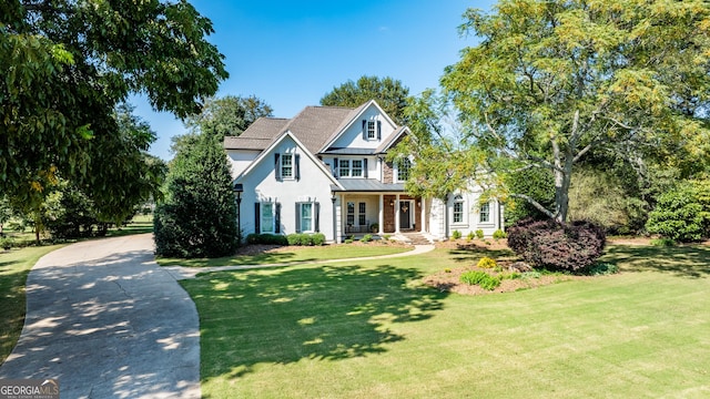 view of front facade with a standing seam roof, metal roof, a front lawn, and stucco siding