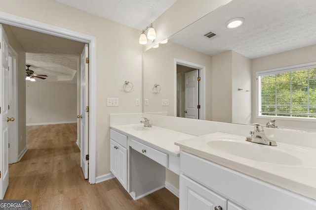 full bath featuring wood finished floors, visible vents, a sink, and double vanity