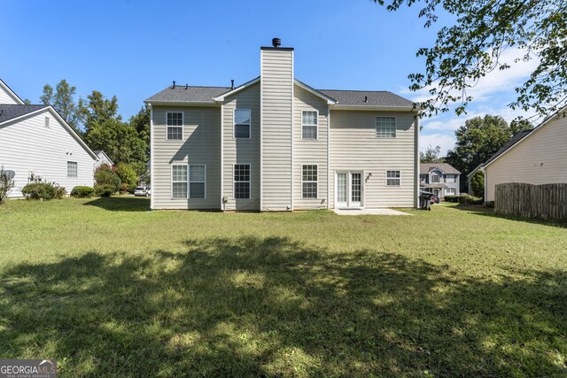 back of house featuring a yard and a chimney