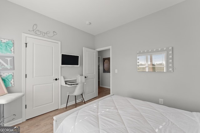 bedroom with baseboards and wood finished floors