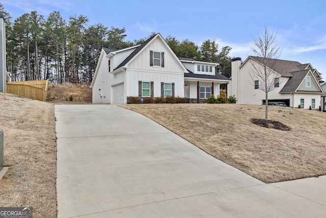 modern farmhouse with a garage, concrete driveway, and board and batten siding