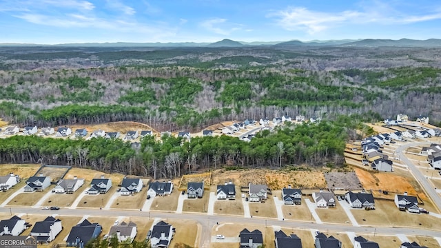 birds eye view of property featuring a residential view, a mountain view, and a wooded view