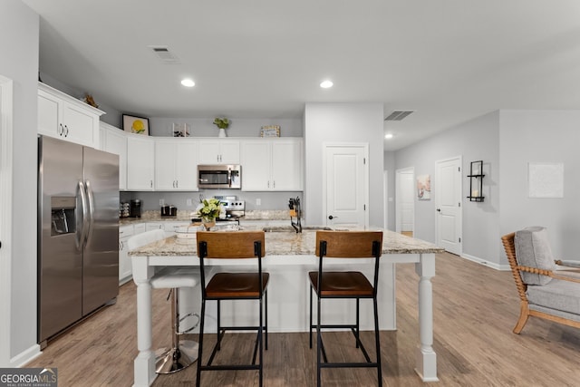 kitchen featuring stainless steel appliances, visible vents, and light wood-style floors