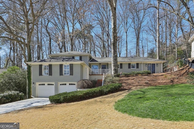 view of front of home featuring a front yard, an attached garage, brick siding, and concrete driveway