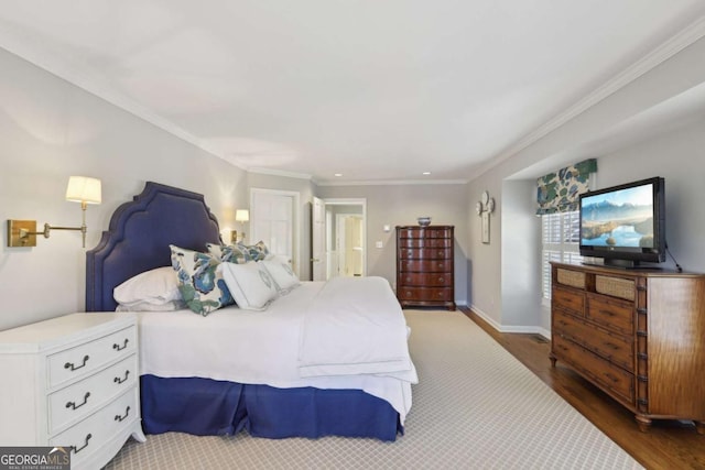 bedroom with crown molding, wood finished floors, and baseboards