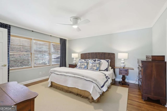 bedroom with baseboards, wood finished floors, and a ceiling fan