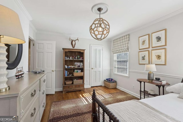 bedroom with a closet, dark wood-type flooring, baseboards, and ornamental molding