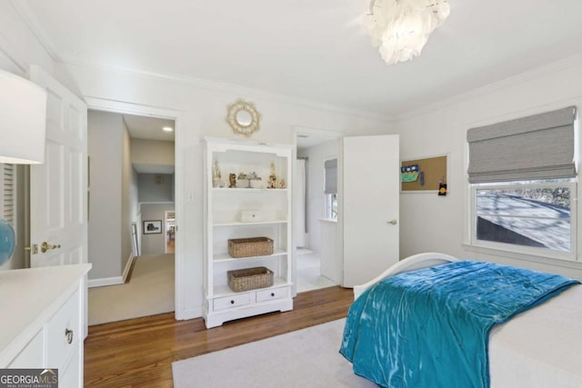 bedroom featuring a notable chandelier, ornamental molding, and wood finished floors