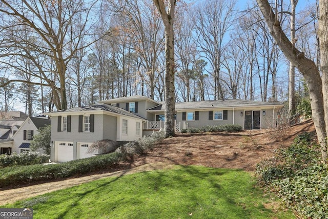 view of front of home with a front yard, brick siding, and an attached garage